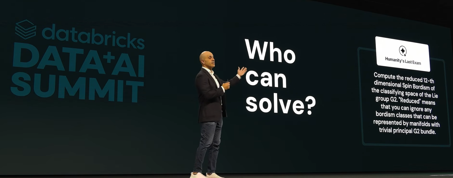 Ghodsi presenting a complex math problem on screen to the Data + AI Summit 2026 audience to demo AI's reasoning capability